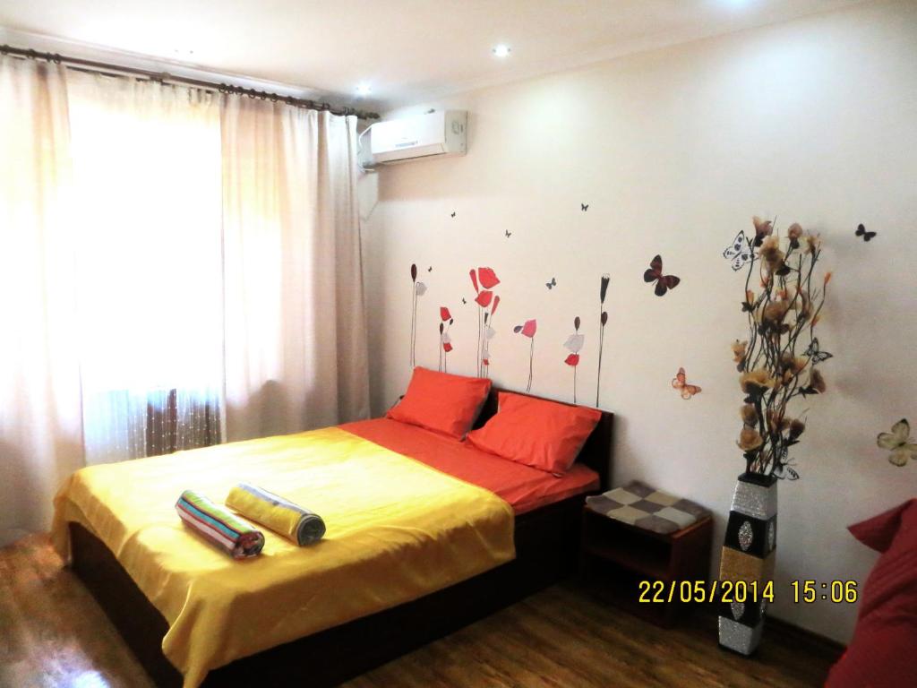 een slaapkamer met een bed met rode kussens en vlinders aan de muur bij Best-BishkekCity Apartment 3 in Bisjkek
