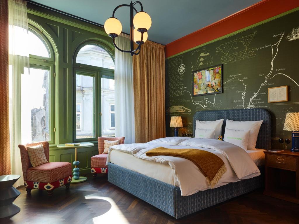 a bedroom with a bed and a green wall at 25hours Hotel Indre By in Copenhagen