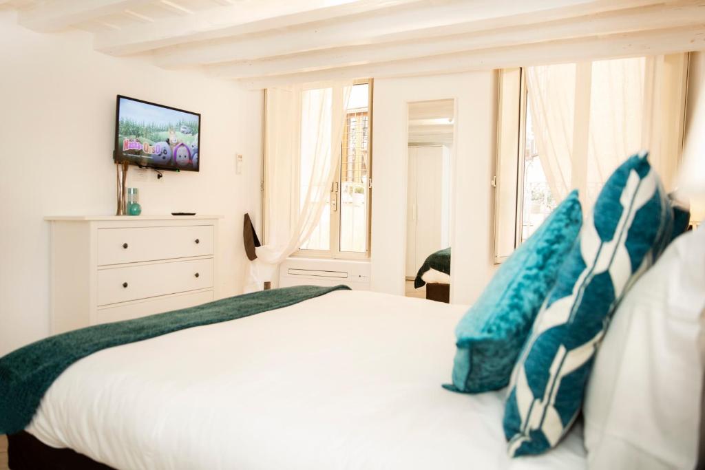 a bedroom with a white bed with blue pillows at Maison Tartarughe in Rome