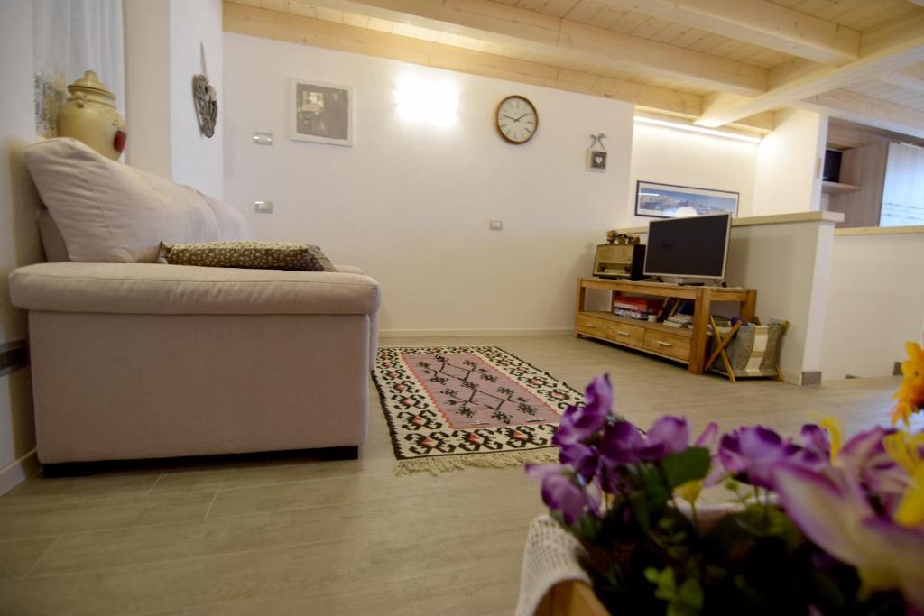sala de estar con sofá y TV en APPARTAMENTO GIRASOLE, en Carano