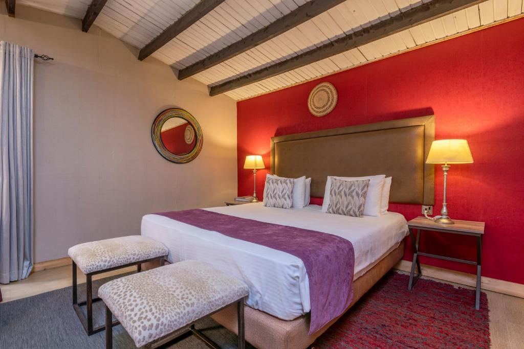 een slaapkamer met een groot bed en rode muren bij Fair Acres Boutique Hotel Karen in Nairobi