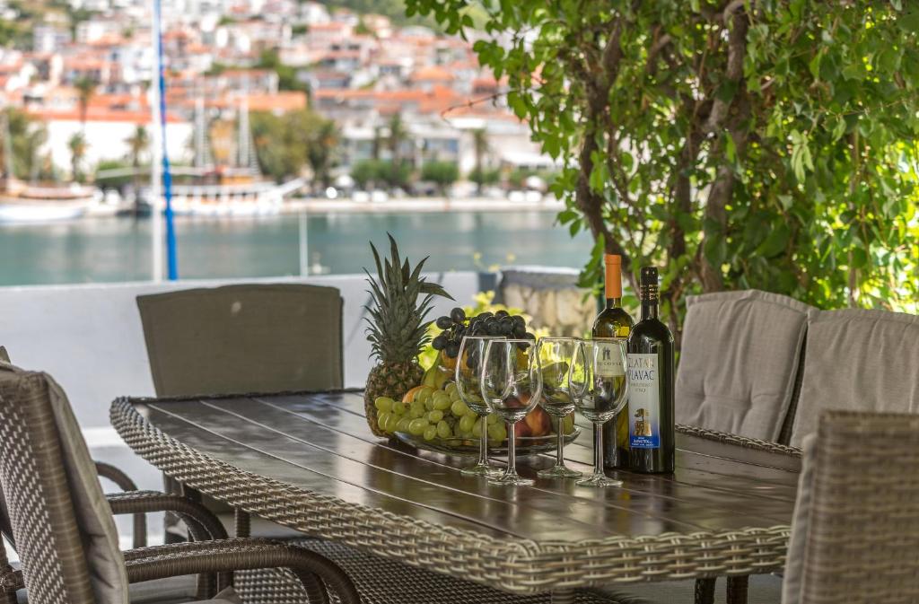 a table with a bowl of fruit and wine glasses at Apartment Alen in Makarska
