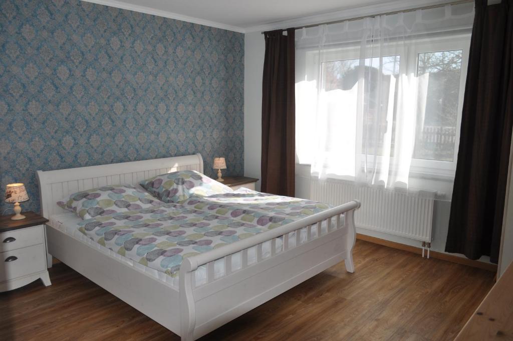 ein Schlafzimmer mit einem weißen Bett und einem Fenster in der Unterkunft Ferienwohnung am Bauernhof in Behrensdorf