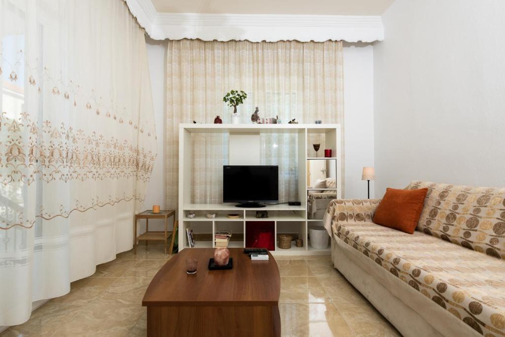salon z kanapą i telewizorem w obiekcie Aigli House w mieście Skala Kallirachis