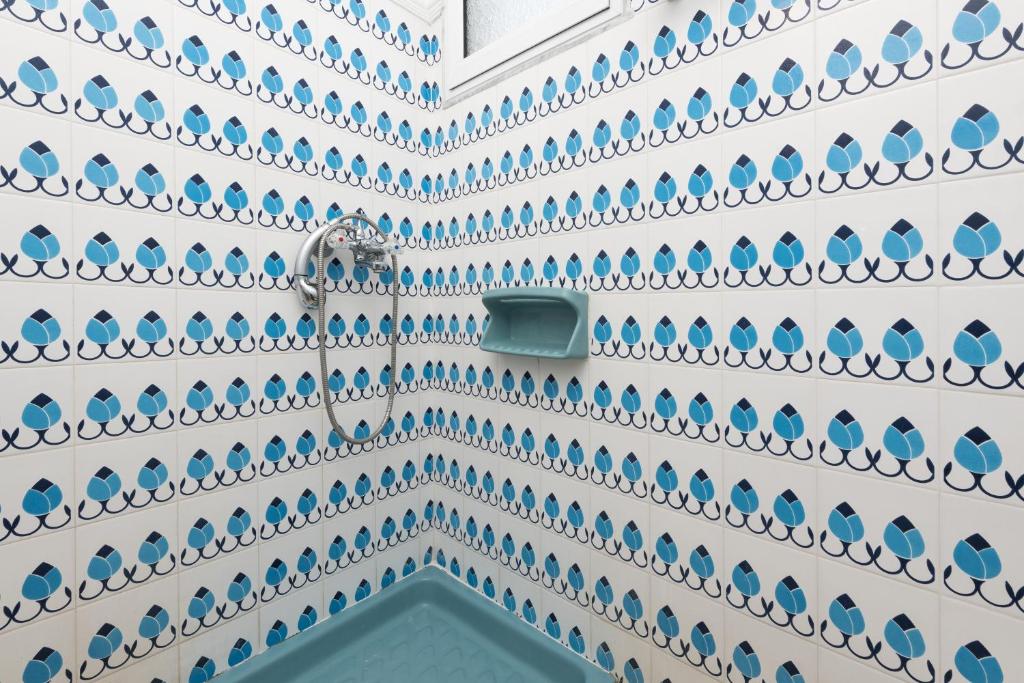 ściana pokryta niebiesko-białą ceramiką w obiekcie Aigli House w mieście Skala Kallirachis
