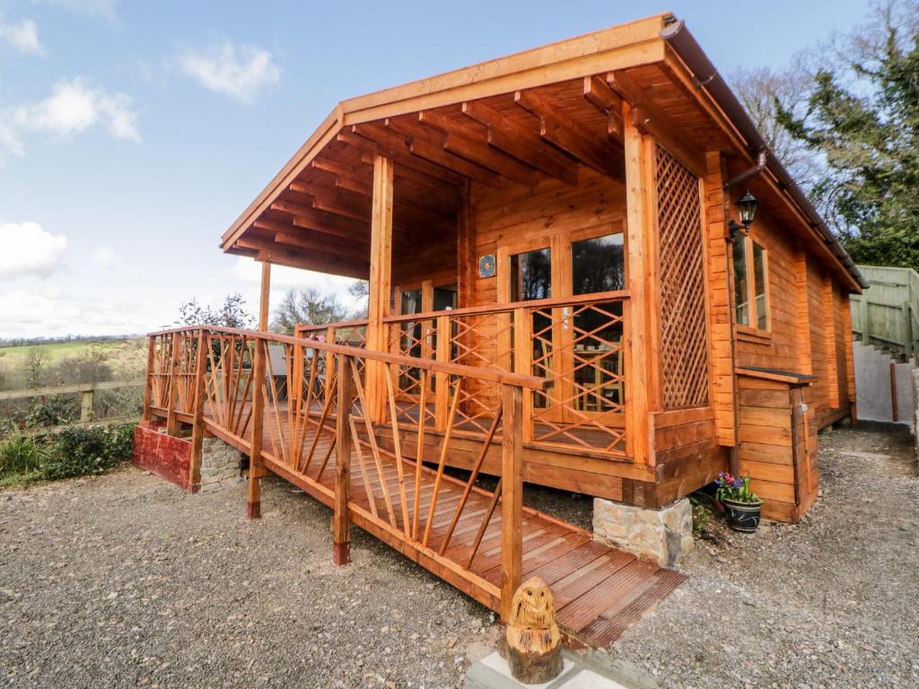 a large wooden cabin with a large deck at Bearscombe View in Ivybridge