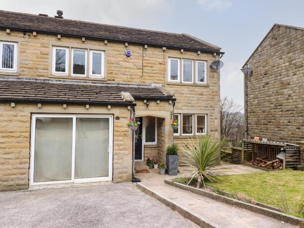 a house with a large garage in front of it at Bronte View Cottage in Keighley