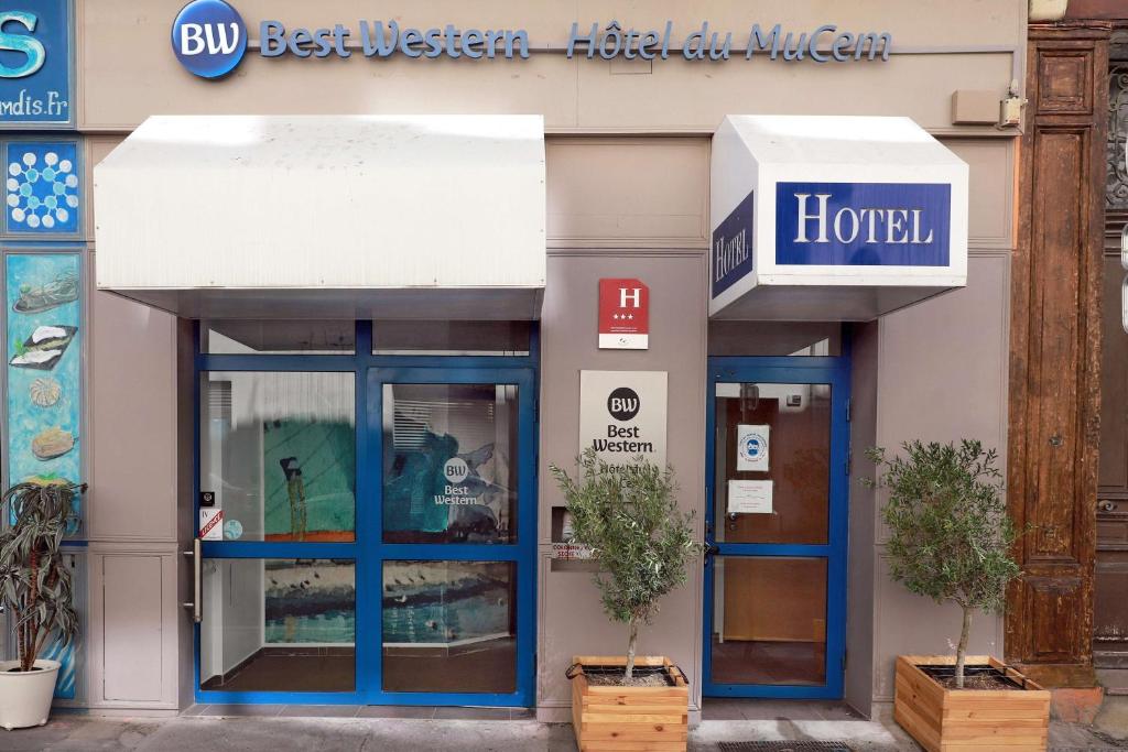 un devant de magasin avec des portes bleues et un panneau sur celui-ci dans l'établissement Best Western Hotel du Mucem, à Marseille