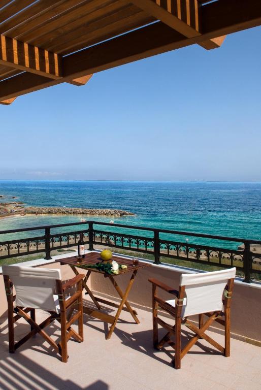 a balcony with a table and chairs and the ocean at Christina Apartments in Panormos Rethymno