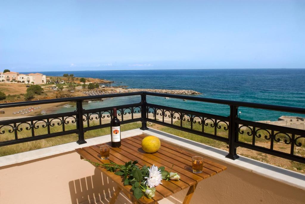 a table on a balcony with a view of the ocean at Apartments Christina in Panormos Rethymno