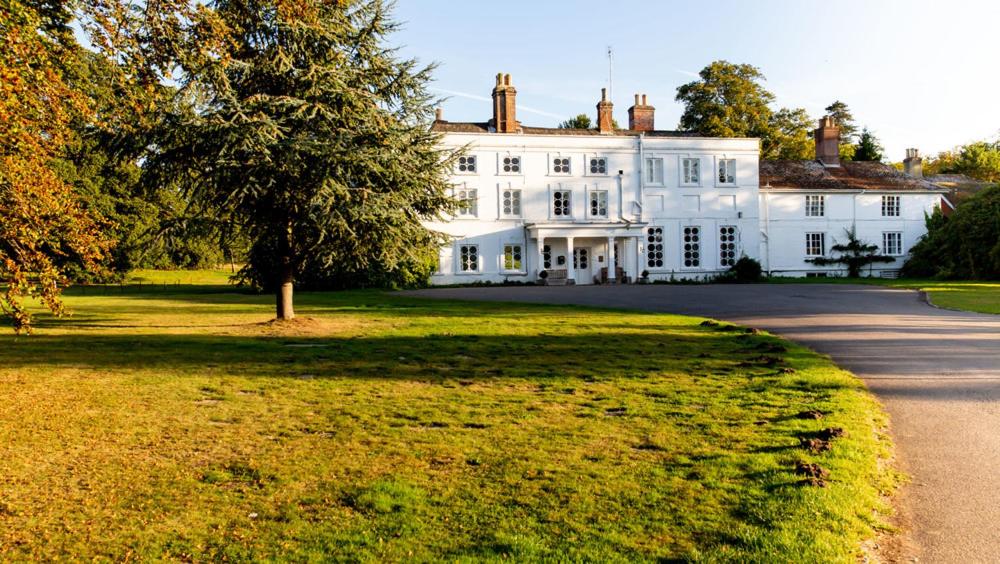 a large white house with a tree in front of it at Foxlease in Lyndhurst