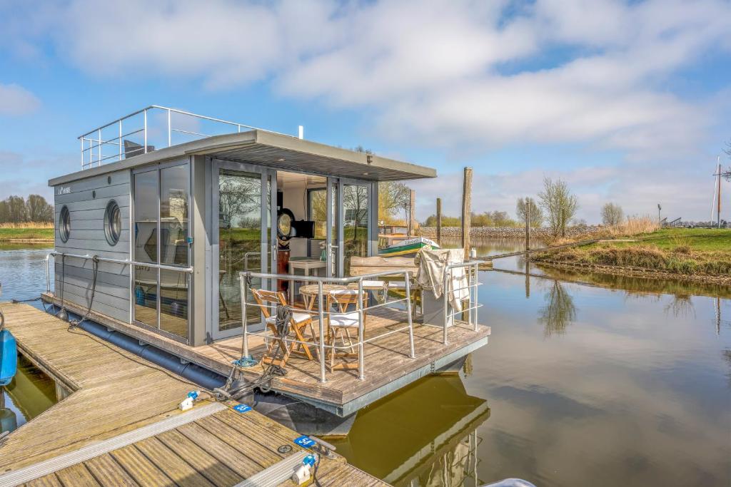 a house on a dock on a body of water at Tiny Hanzeboat in Hattem