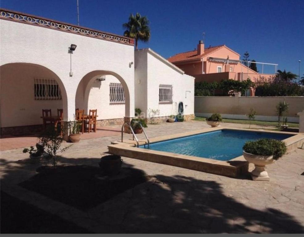 una piscina frente a un edificio blanco en La Calma del Delta en L'Eucaliptus