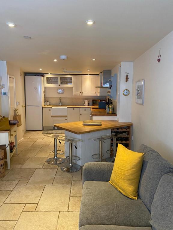 a living room with a couch and a kitchen at Reduced rates for this month! Beautiful cottage, 3 stories high with upstairs courtyard and set in an amazing location! The fantastic newly developed Town Mill with restaurants and craft shops on your doorstep Also only 2 minutes to the sea! , Sleeps 4 in Lyme Regis