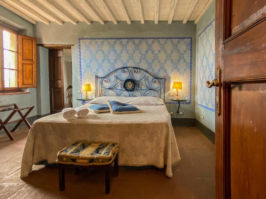 um quarto com uma cama grande e uma parede azul em Antica Dimora Leones em Palaia