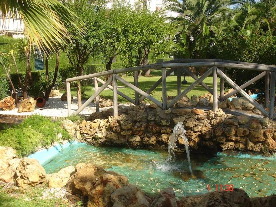un puente sobre una piscina de agua con una cascada en Islantilla a 50 metros de la playa, en Islantilla