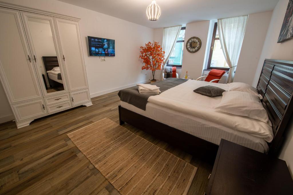 a bedroom with a large bed and a mirror at Old Town Suites Brașov in Braşov