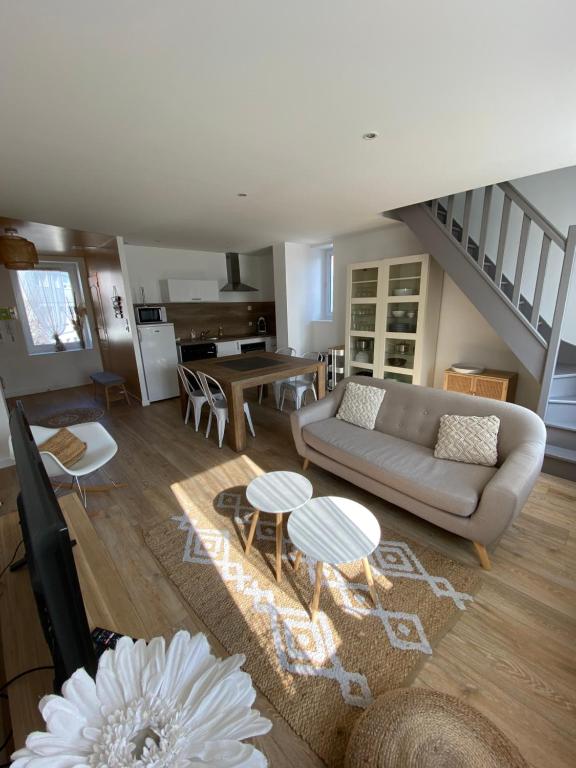 a living room with a couch and a table at Le Presbytère des Baraques à Blériot-Plage - Apt 3 in Sangatte