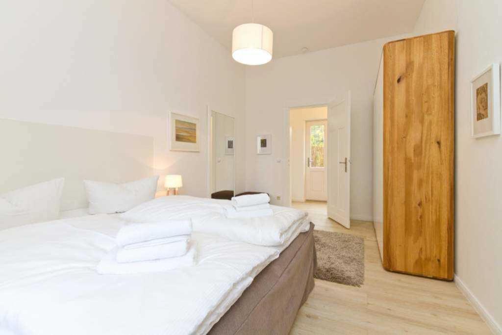 un grande letto bianco in una stanza con porta in legno di Villa Diehl App 1 a Heringsdorf
