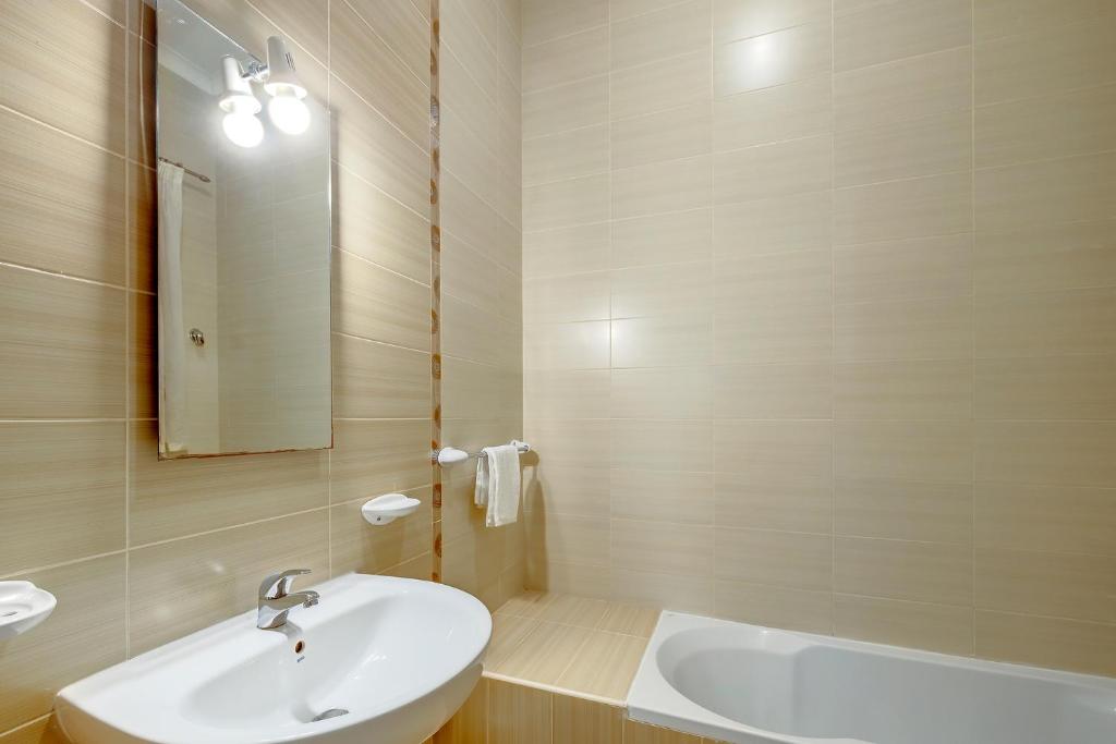 a bathroom with a sink and a mirror and a tub at Modern 2 Bedroom Maisonette in Central Sliema in Sliema