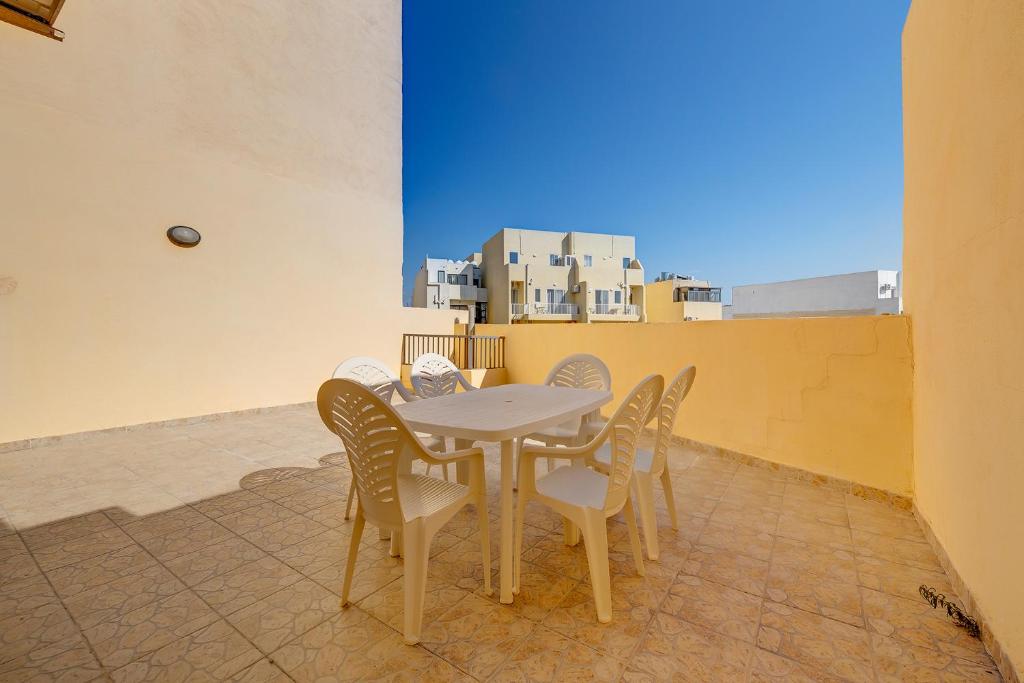 a table and chairs on a balcony with a view at Modern 2 Bedroom Maisonette in Central Sliema in Sliema