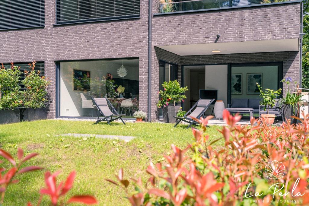 two chairs in a yard in front of a building at La Perla in Lindau