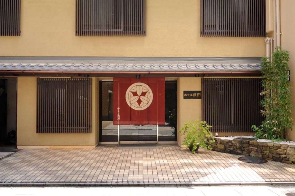a building with a red door with a sign on it at Hotel Iida in Kyoto
