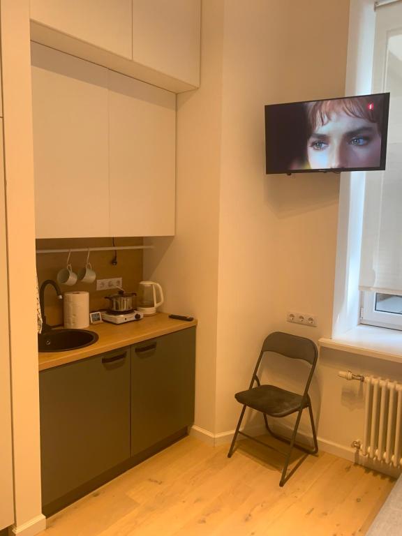 a kitchen with a television hanging from the wall at Verman Park Apartment in Rīga