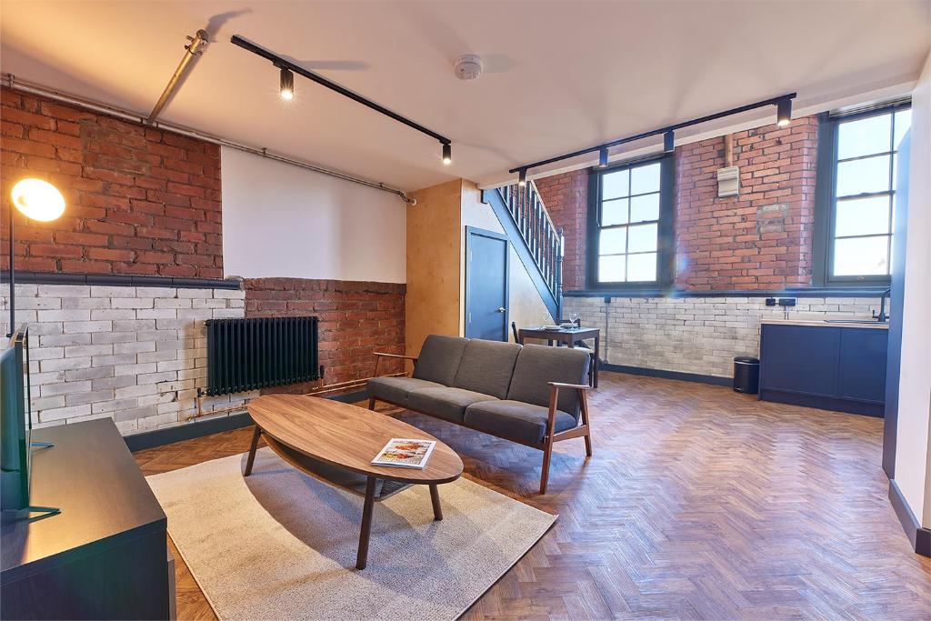 uma sala de estar com um sofá e uma mesa em No 8 at Simpson Street Apartments Sunderland em Sunderland