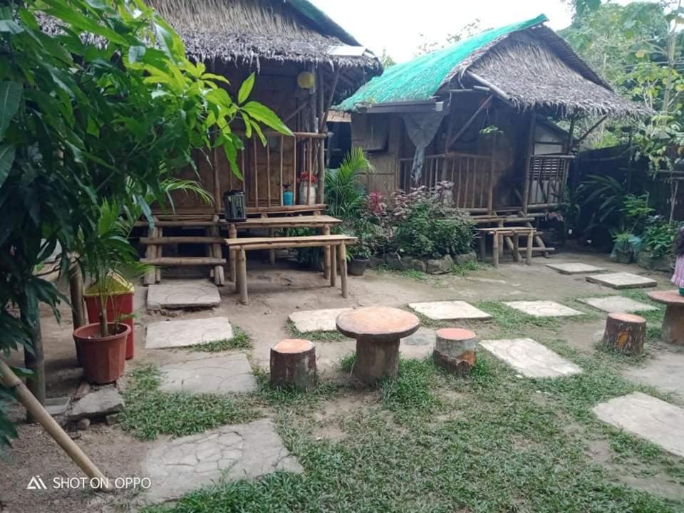 un jardín frente a una casa con taburetes en Kambal Kubo Resthouse at Sitio Singalong Bgy San Jose Antipolo en Antipolo