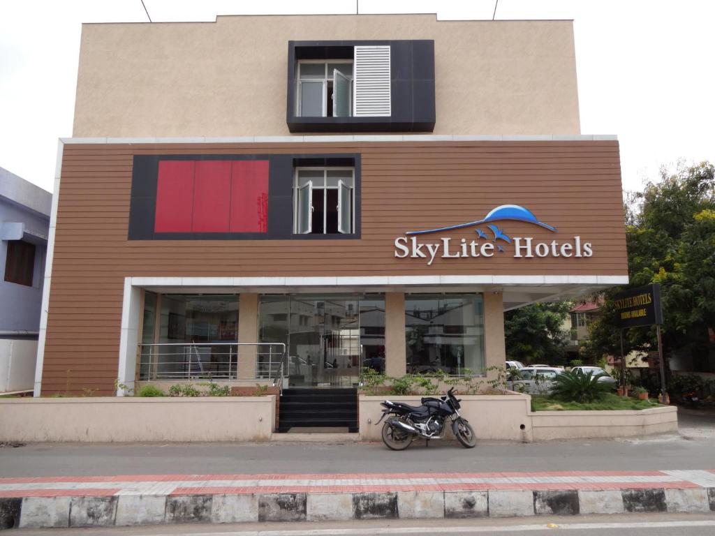 uma moto estacionada em frente a um edifício em Hotel Sky Lite em Coimbatore