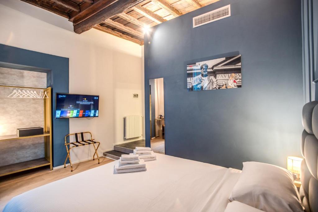a bedroom with a bed and a tv on a wall at Capranica Private Suites in Rome