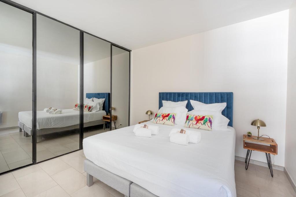 a bedroom with a large white bed with mirrored walls at 45 Croisette Apartment - Prime Location - Beach & Palais by Foot - AC in Cannes