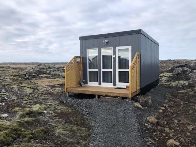 a tiny house sitting on top of a field at Reykjavík Outskirts - Minimalist Escape in Vogar