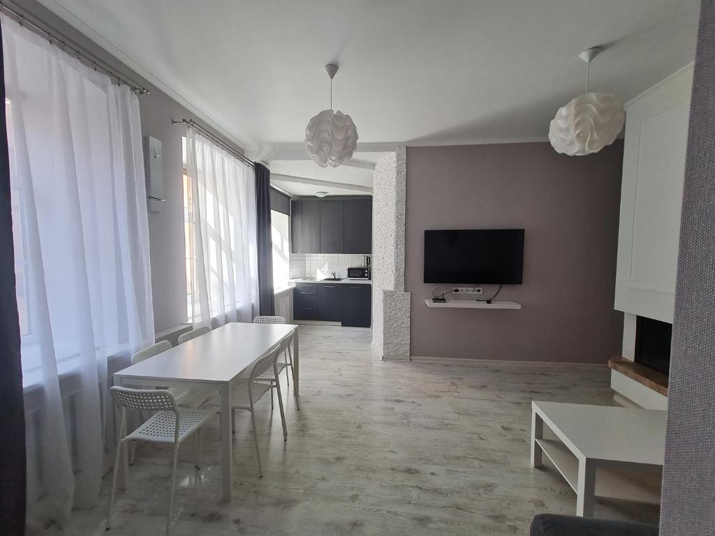 a living room with a white table and chairs at Central Star in Daugavpils