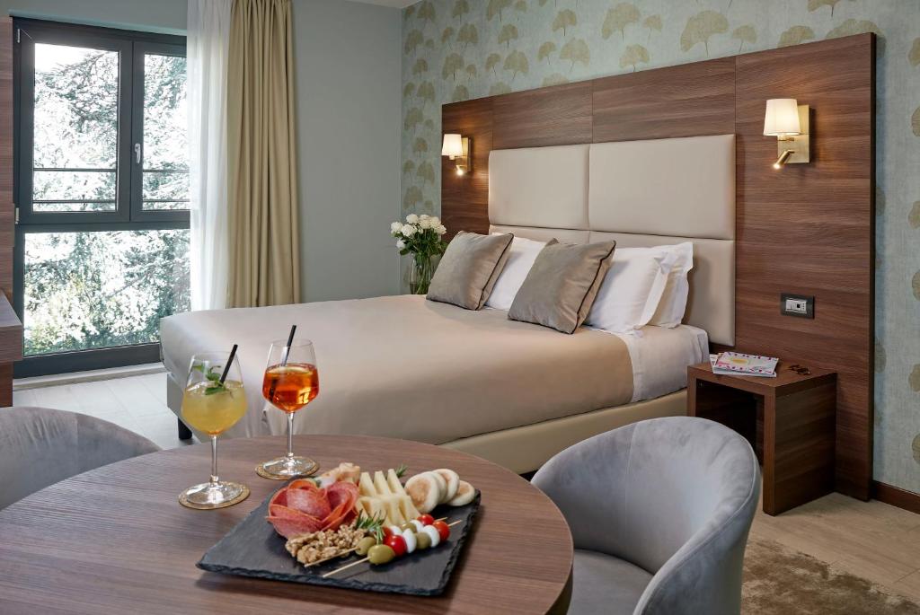 a hotel room with a bed and a table with a tray of food at Hotel Spigamonti in Negrar