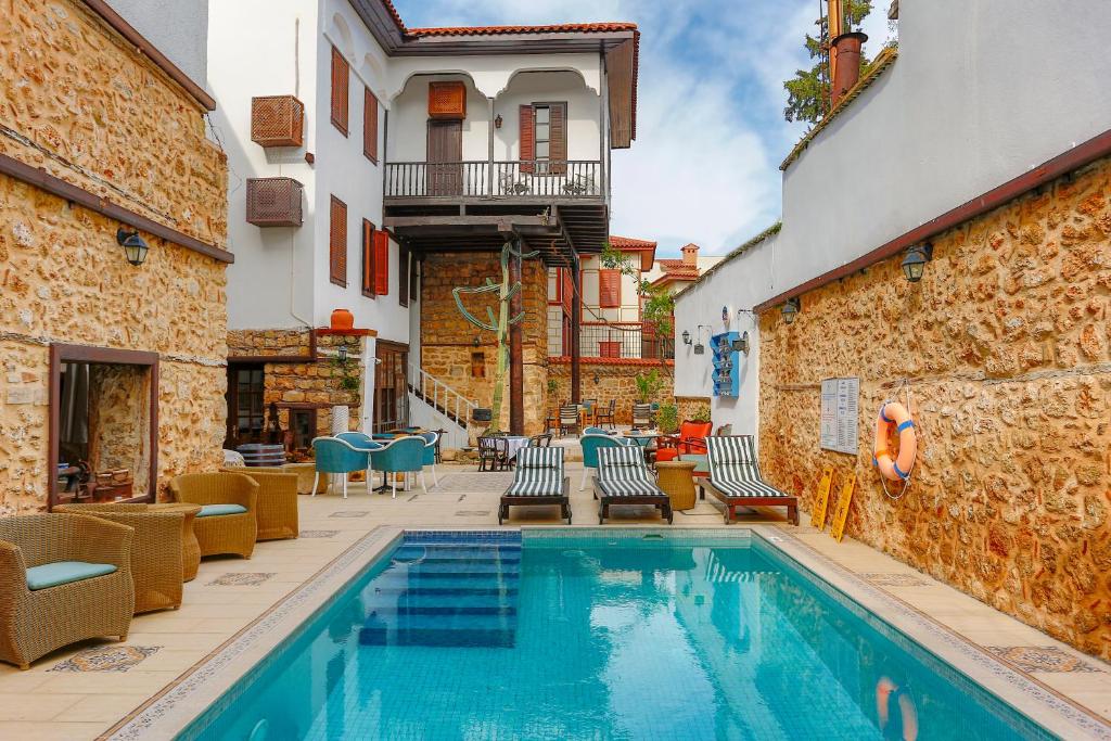 a swimming pool in a courtyard with chairs and a building at Atelya Art Hotel in Antalya