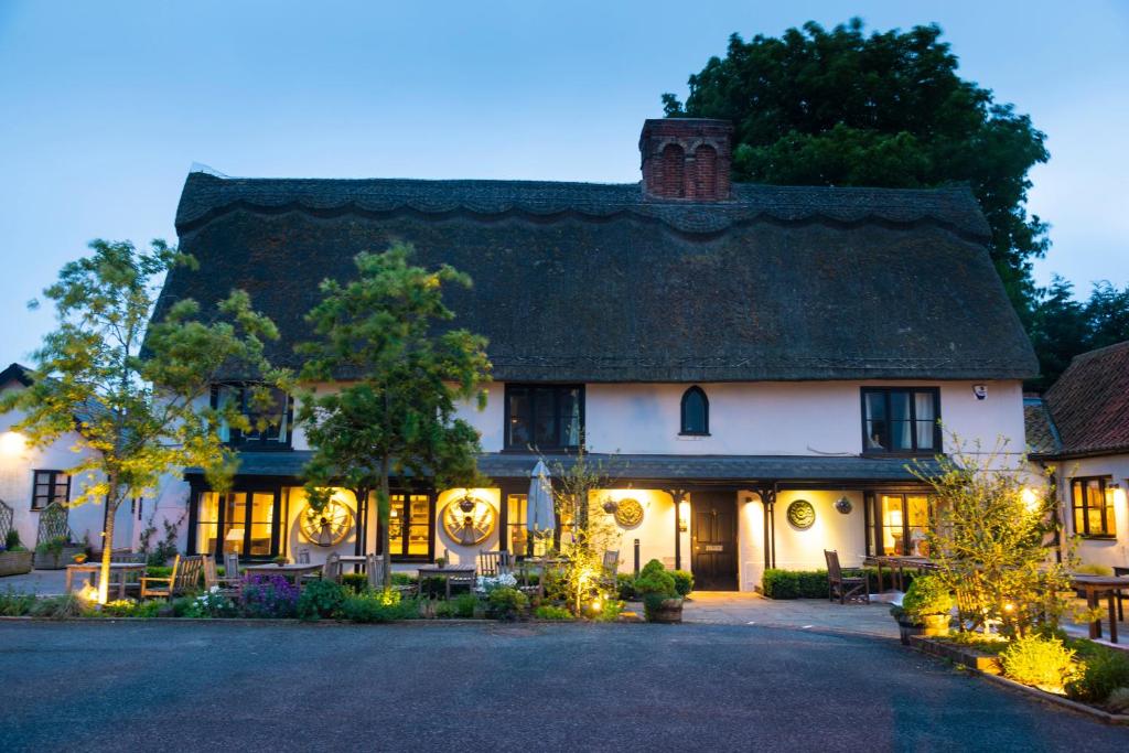 Una gran casa blanca con luces de Navidad. en The Black Bull Inn en Balsham