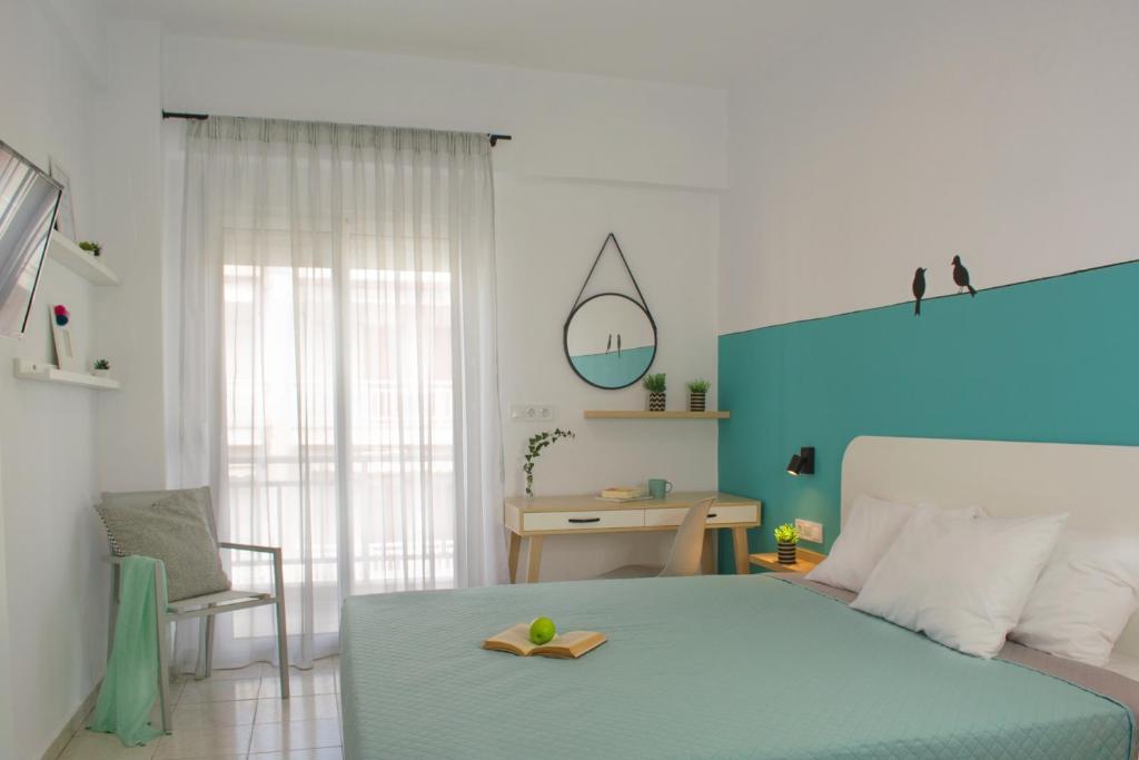 a bedroom with a bed and a desk with a mirror at Kochyli Beach Studios in Nea Plagia