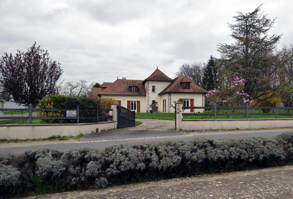 a house with a fence in front of a road at La Peyrova in Saint-Sulpice-les-Feuilles