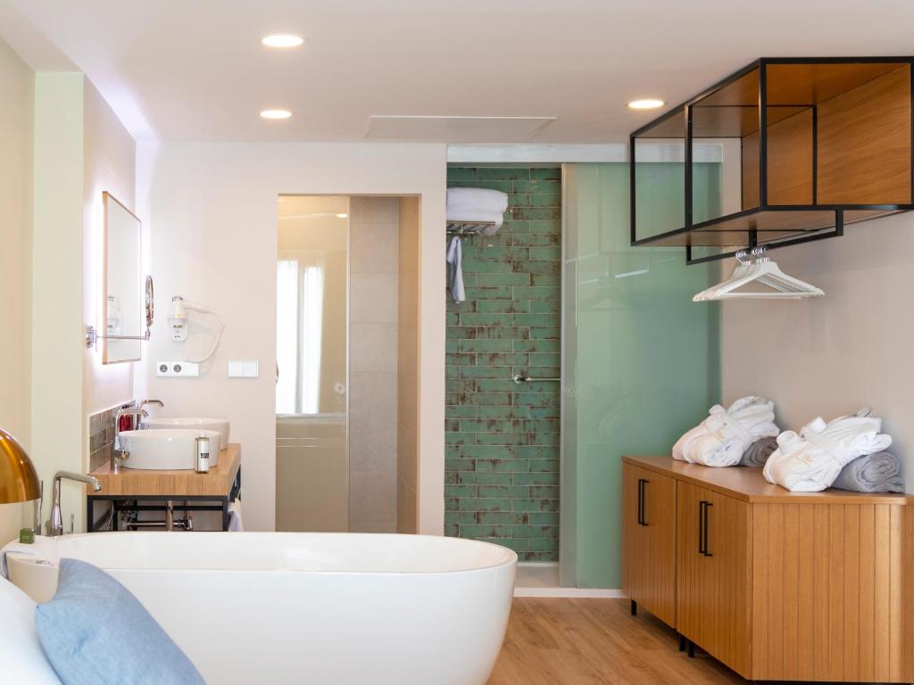 a bathroom with a bath tub and a sink at Alexandre Grand Teguise Playa in Costa Teguise
