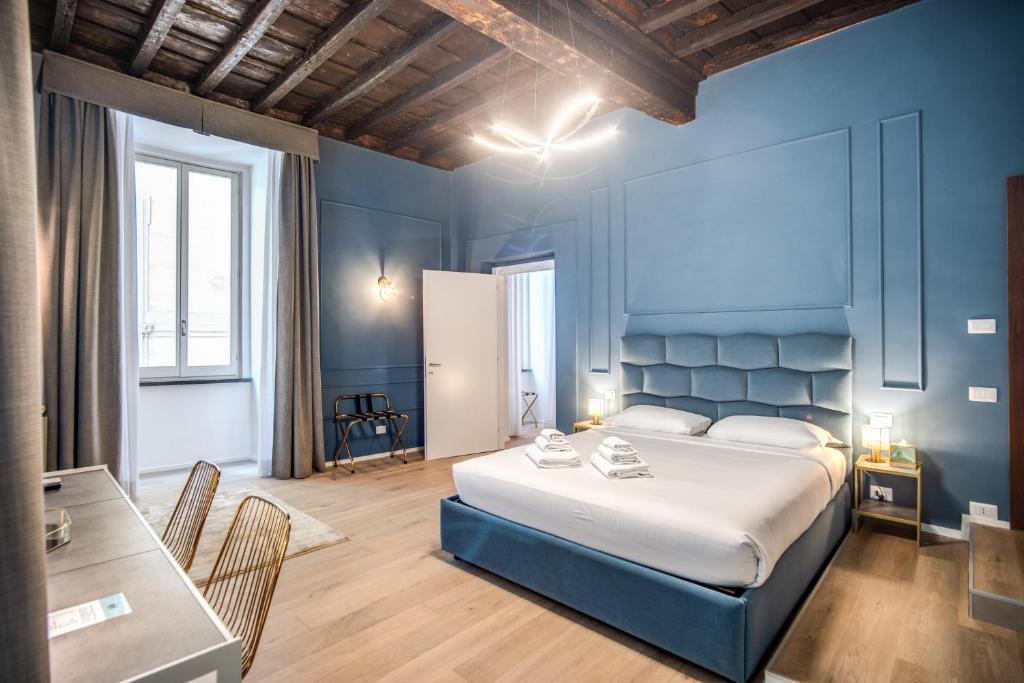 a blue bedroom with a bed and a table at Capranica Private Suites in Rome