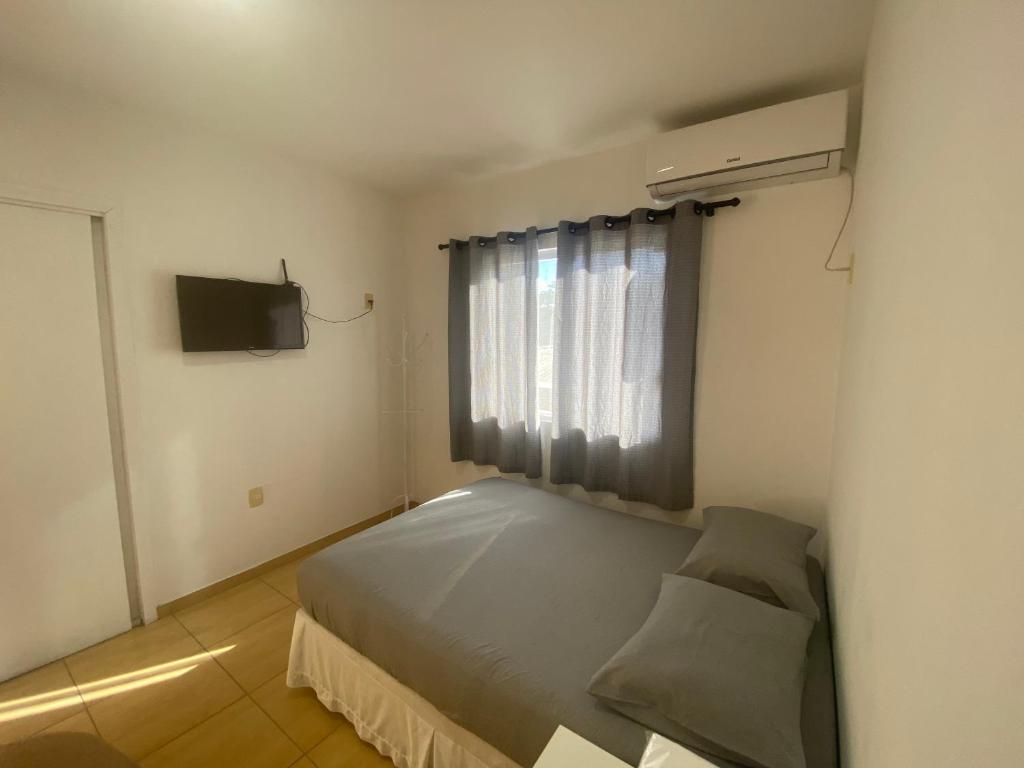 a small bedroom with a bed and a window at AP frente à praça bem localizado in São José