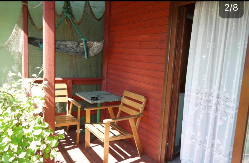 a table and chairs on the porch of a house at Domki Letniskowe in Jastarnia