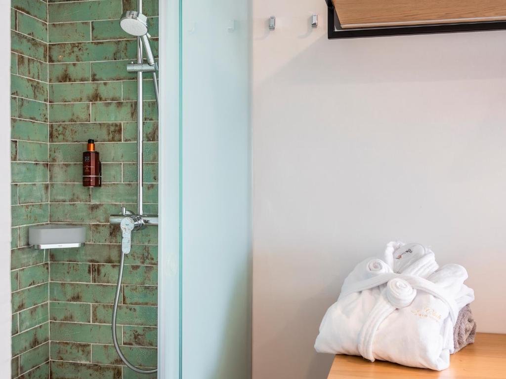 a bathroom with a shower with a white towel at Alexandre Grand Teguise Playa in Costa Teguise