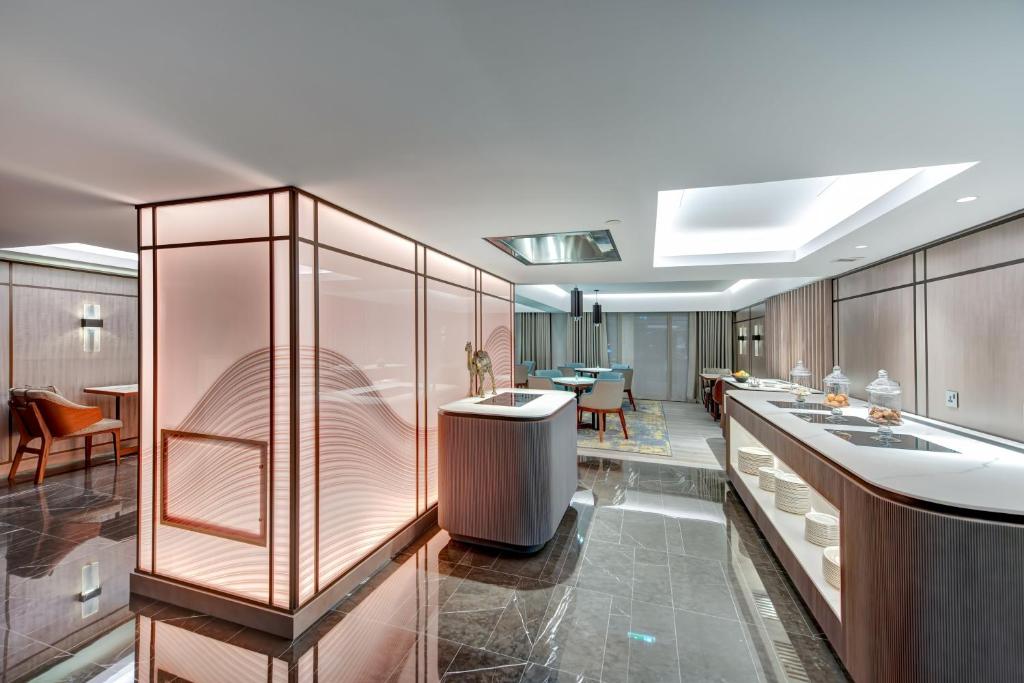 a kitchen with a counter and a dining room at InterContinental Muscat by IHG in Muscat