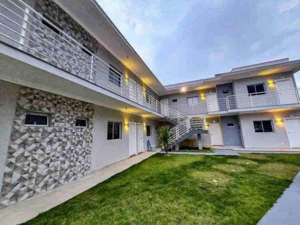 ウバトゥバにあるApto terreo com piscina, quintal e churrasqueiraの草の庭のある建物の外観