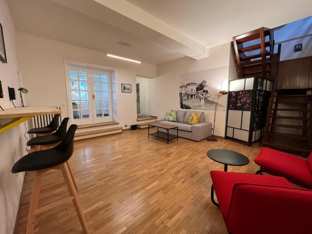 ein Wohnzimmer mit einem roten Sofa und Stühlen in der Unterkunft Accanto alla piazza in Bologna
