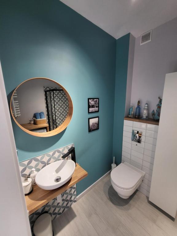 W łazience znajduje się biała toaleta i lustro. w obiekcie APARTAMENT przy jeziorze w Bornem-Sulinowie
