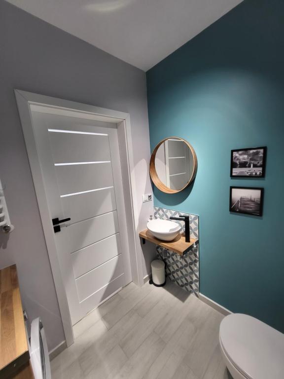 W łazience znajduje się biała toaleta i lustro. w obiekcie APARTAMENT przy jeziorze w Bornem-Sulinowie